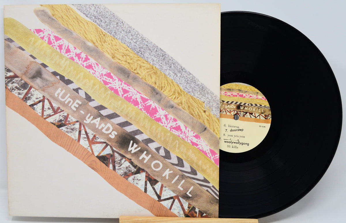 Vinyl record album with a colorful abstract cover design and a black LP partially pulled from the sleeve, photographed on a light gray background.