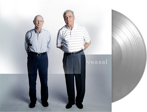 Two men standing side by side with a silver vinyl record on a white background, featuring the brand 'vessel'.
