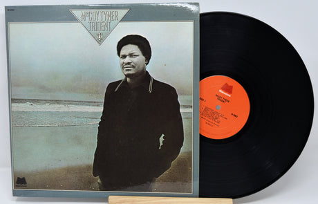 Vinyl record with a cover featuring a person on a beach, on a white background