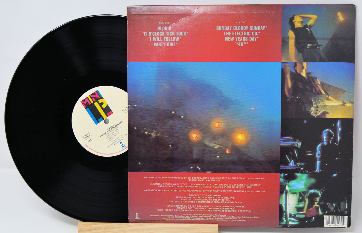 Vinyl record with colorful album cover featuring concert images and text.