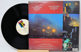 Vinyl record with colorful album cover featuring concert images and text.
