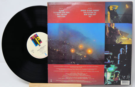 Vinyl record with colorful album cover featuring concert images and text.