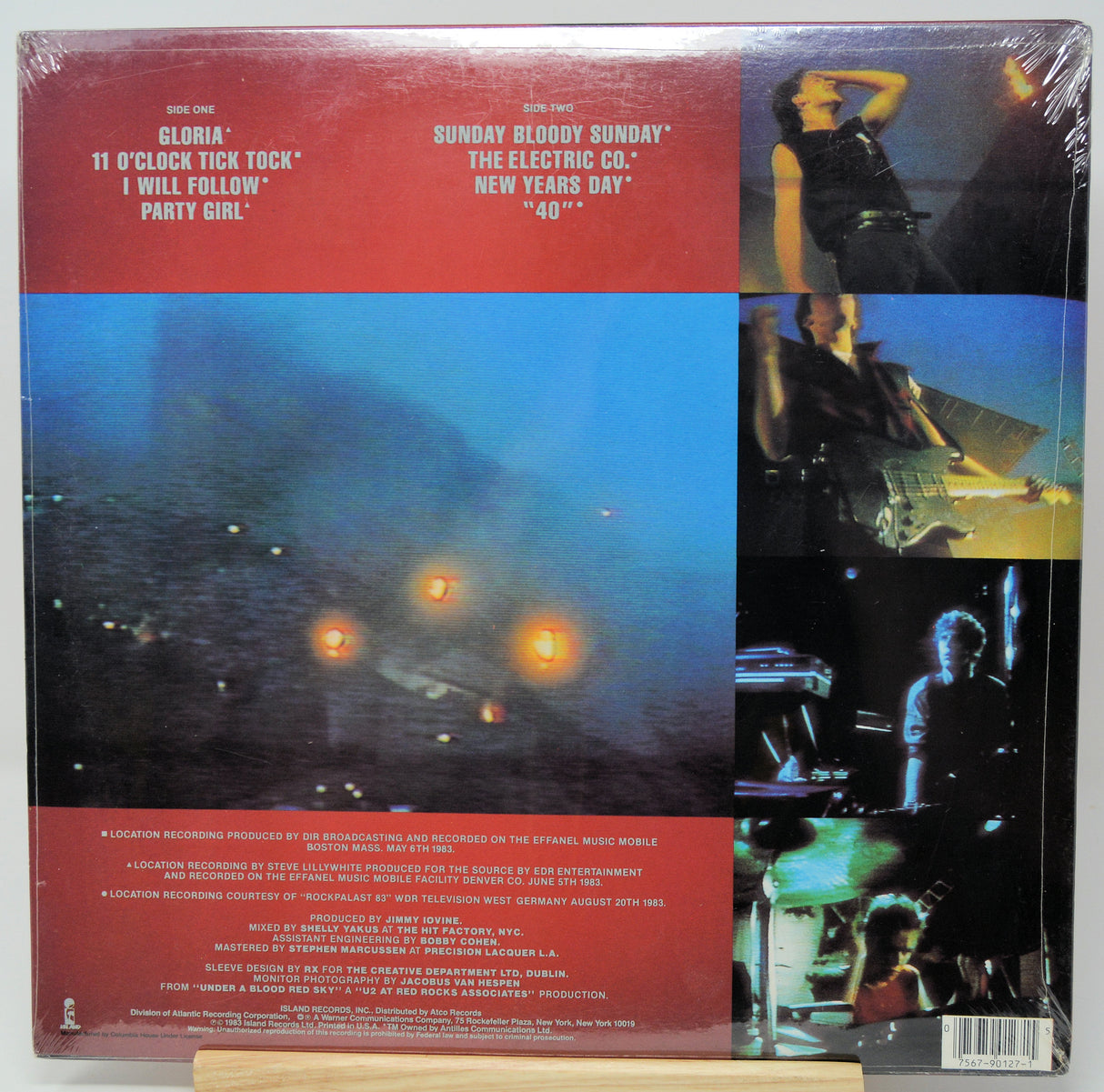 Back cover of a vinyl record sleeve for Gloria's '11 o'clock tick tock' / 'I will follow' party girl, featuring red text bands, a large blue-toned beach scene with glowing lights, and a vertical collage of photos on the right side.