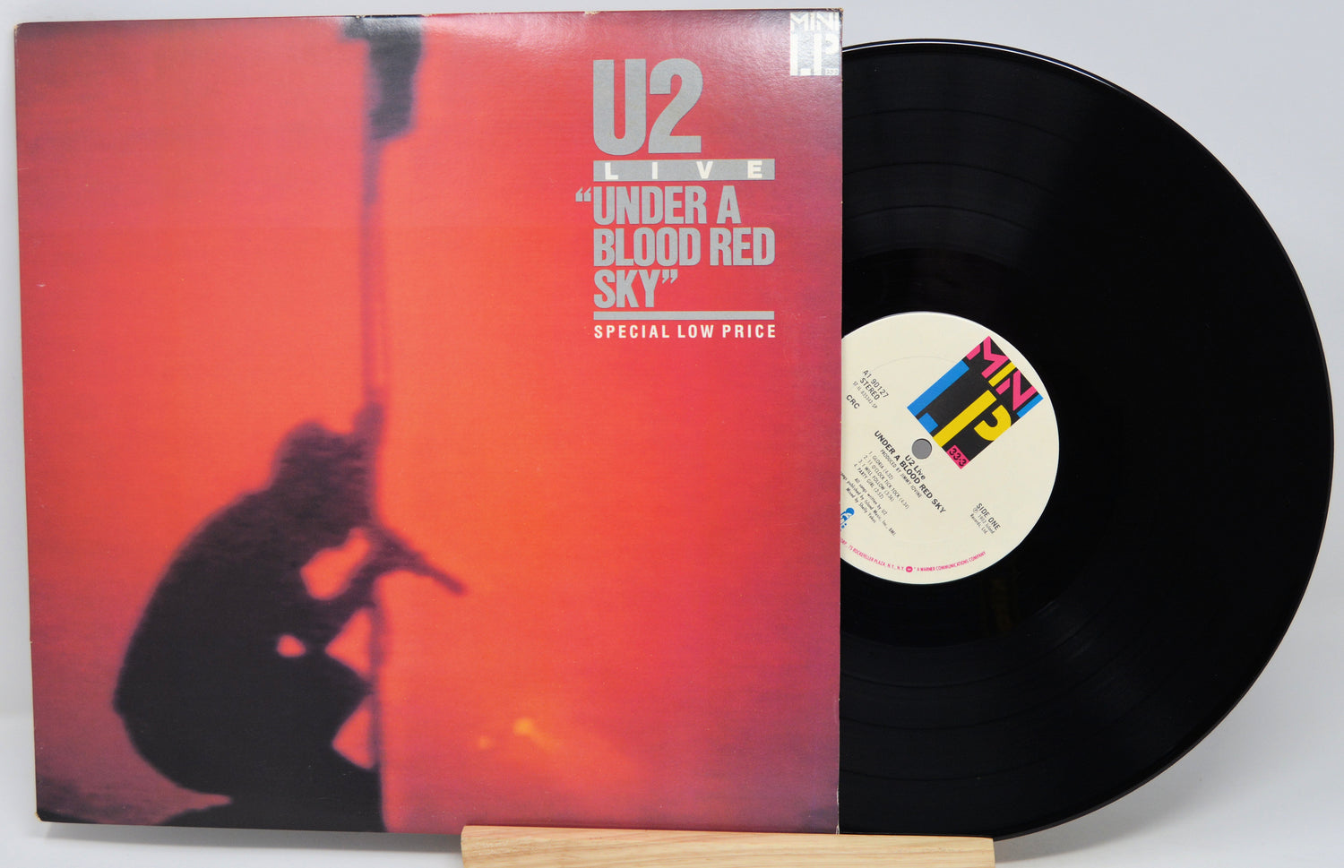 Vinyl record with U2 'Under a Blood Red Sky' cover on a white background