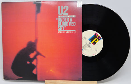Vinyl record with U2 'Under a Blood Red Sky' cover on a white background