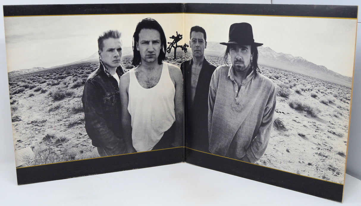 Album cover with four band members in a desert landscape