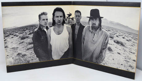 Album cover with four band members in a desert landscape