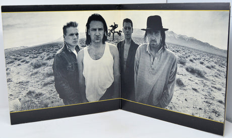 Album cover with a black and white photo of four people in a desert landscape.