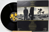 Vinyl record with matching cover featuring desert landscape and people.