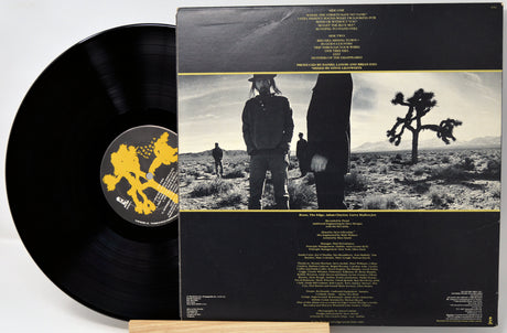 Vinyl record with matching cover featuring desert landscape and people.
