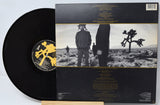 Vinyl record with matching cover featuring a desert landscape and person.