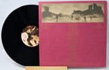 Vinyl record with pink cover featuring a landscape and text