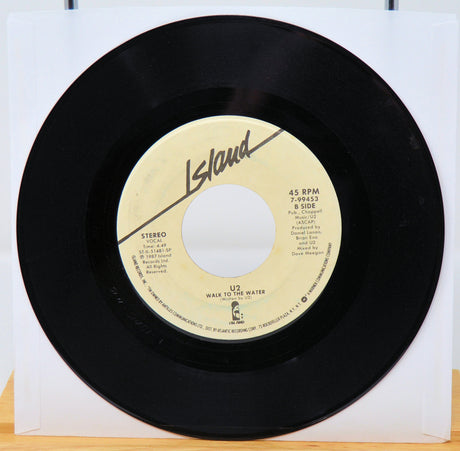 Black vinyl record with yellow label featuring 'Island' and U2 album details on a white background.