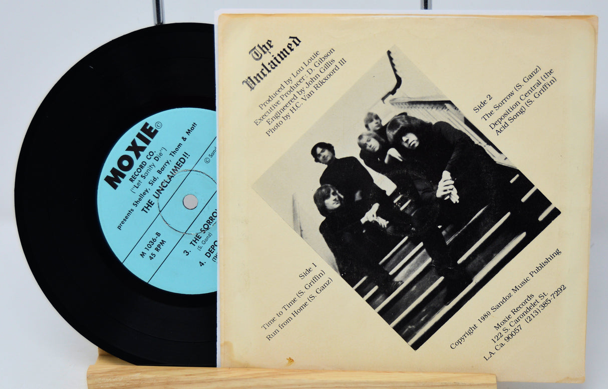 Vinyl record with cover featuring a band photo and text on a white background