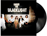 Vinyl record with cover showing a group of people sitting against a wall, titled 'Under the Blacklight'.