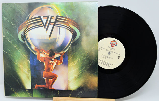 Vinyl record with a colorful cover featuring a person holding a sphere, on a white background.