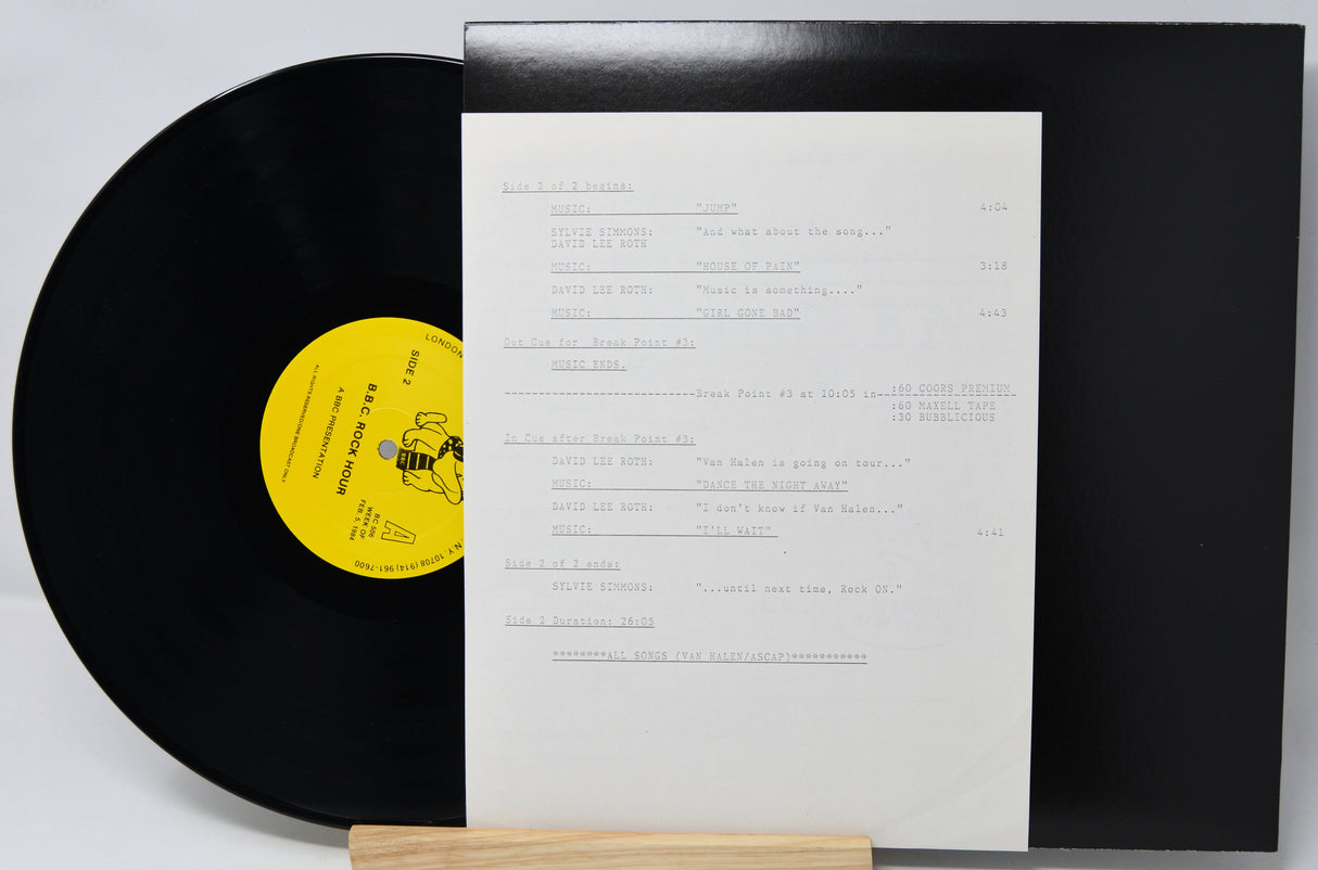 Vinyl record with a yellow label and white inner sleeve on a gray background