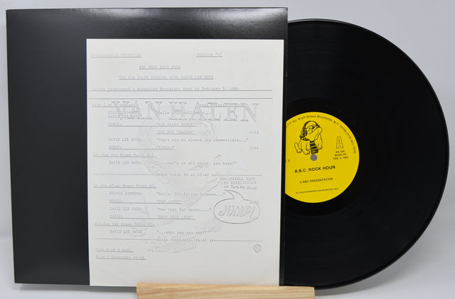 Vinyl record with a yellow label and black cover on a white background