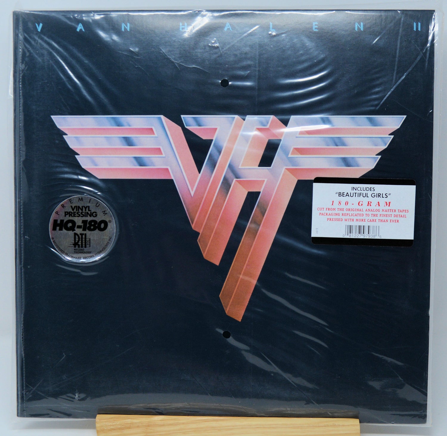 Van Halen II 180g vinyl record in its shrink wrap, featuring the classic metallic 'VH' logo on a black background, with a 'Includes: "Beautiful Girls"' sticker and a 'Vinyl Pressing HQ-180' label.