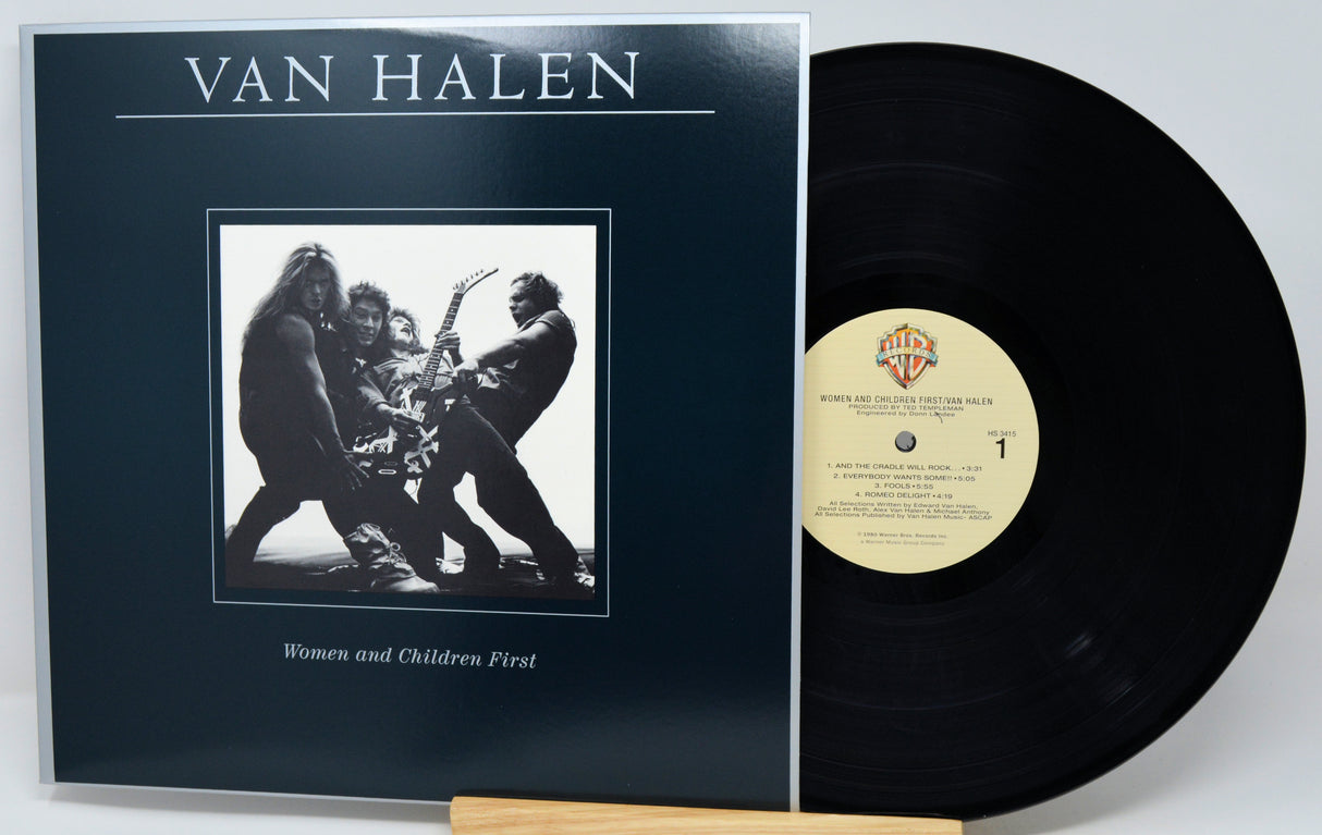 Van Halen 'Women and Children First' vinyl record with the black LP partially pulled from the sleeve, photographed on a light gray background.