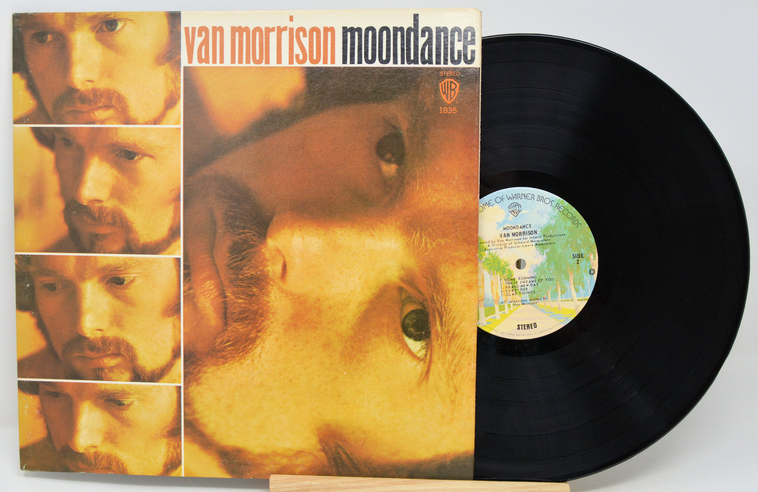 Van Morrison's 'Moondance' vinyl record album with the LP partially pulled from the jacket, showing the black record and the cover art on a light background.
