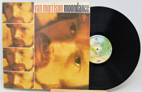 Van Morrison's 'Moondance' vinyl record album with the LP partially pulled from the jacket, showing the black record and the cover art on a light background.