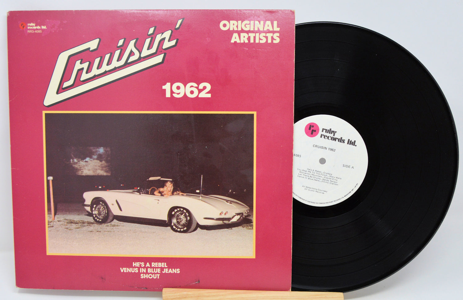 Vinyl record with a pink cover featuring a car and text, on a white background
