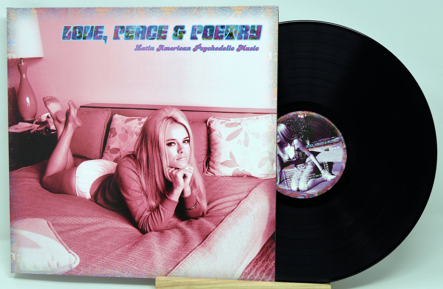 Vinyl record with cover featuring a woman lying on a bed, titled 'Love, Peace & Poetry'.