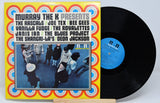 Vinyl record with colorful cover featuring artist names and a band photo.