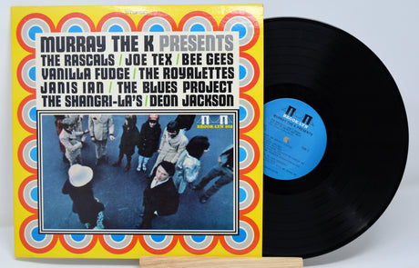 Vinyl record with colorful cover featuring artist names and a band photo.