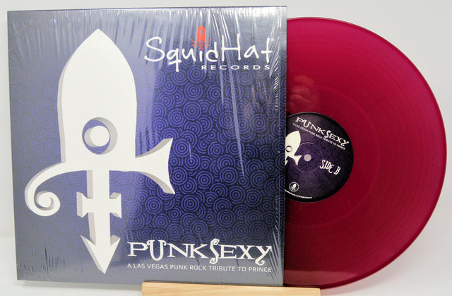 Vinyl record with red disc and Squid Hat Records packaging on a white background