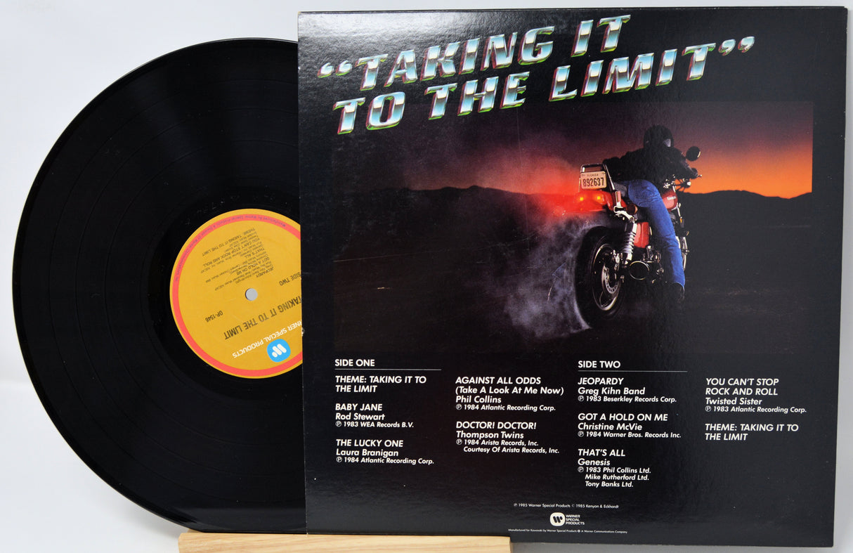 Vinyl record album 'Taking It to the Limit' with the black LP partially visible behind the printed sleeve, photographed on a white background.