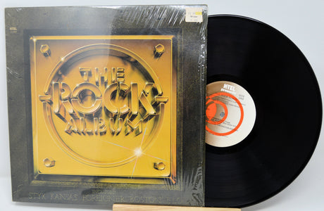 Vinyl record with 'The Rock Album' cover on a white background