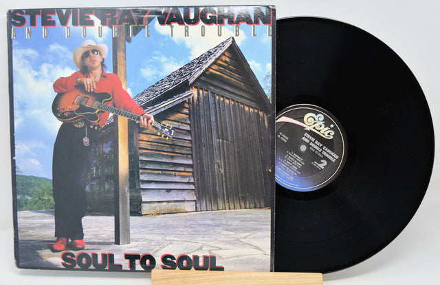 Vinyl record with cover featuring a person holding a guitar, titled 'Soul to Soul' by Stevie Ray Vaughan.