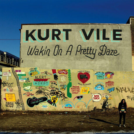 Mural with 'Kurt Vile Wakin On A Pretty Daze' on a building wall.