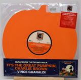 A vinyl record package for the soundtrack to 'It's the Great Pumpkin, Charlie Brown' on a limited edition pumpkin-shaped LP. The record itself is bright orange, and the package includes a dark blue paper sleeve with orange and white text, a red 'Limited Edition Pumpkin-Shaped LP' sticker, and a visible Craft Records logo on the center label and sticker.