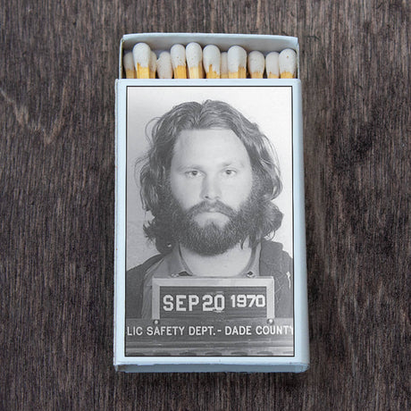 Retro matchbox with a black-and-white vintage mugshot on top, displayed on a wooden surface