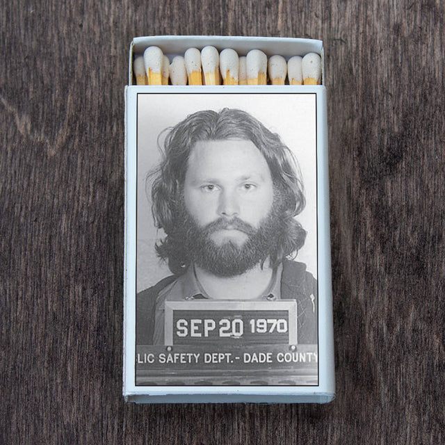 Retro matchbox with a black-and-white vintage mugshot on top, displayed on a wooden surface