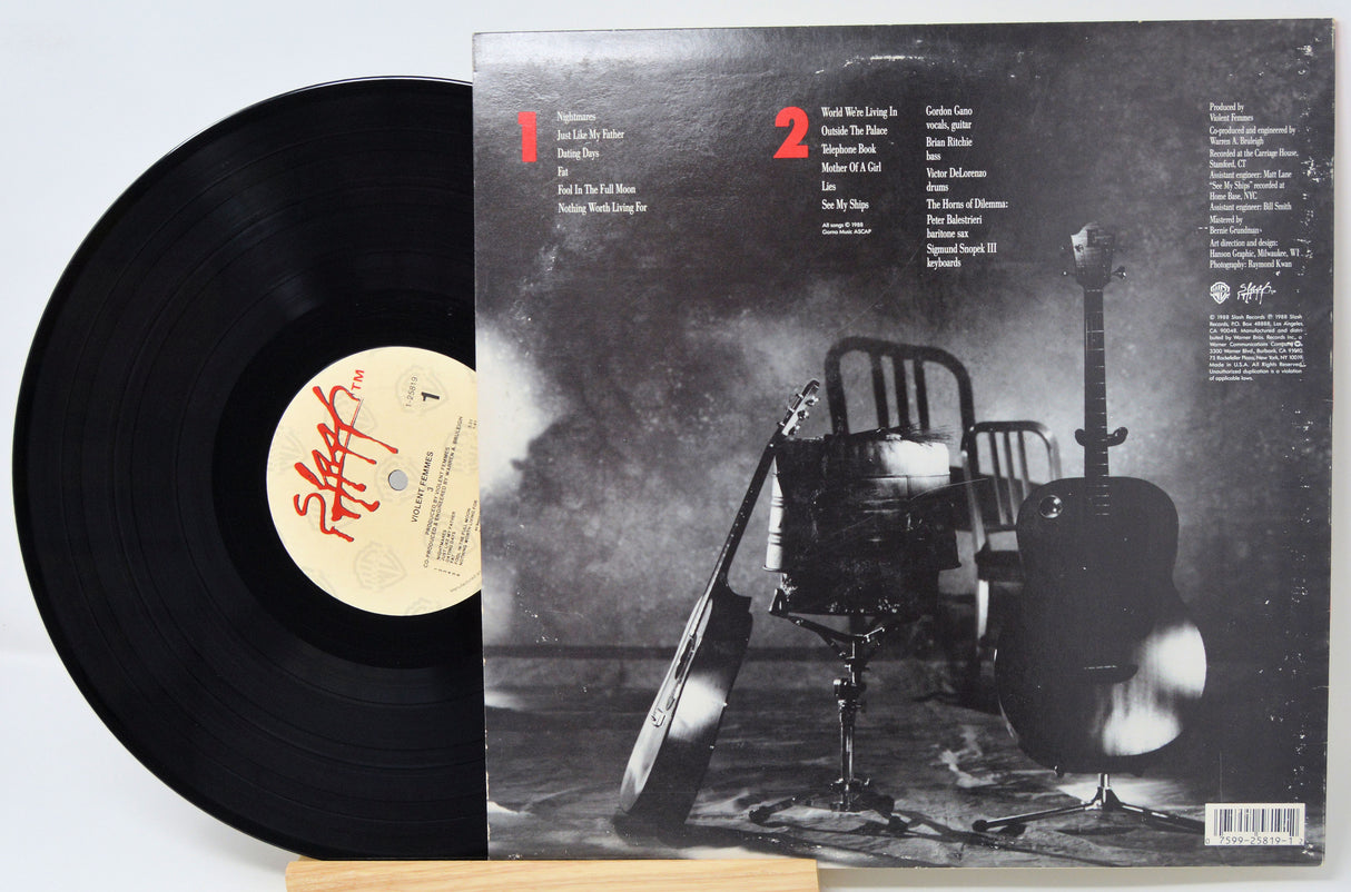 Vinyl record with cover featuring a black and white image of a chair and guitar.