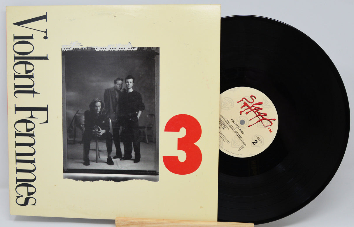 Vinyl record with 'Violent Femmes' album cover showing three people and a red number 3.