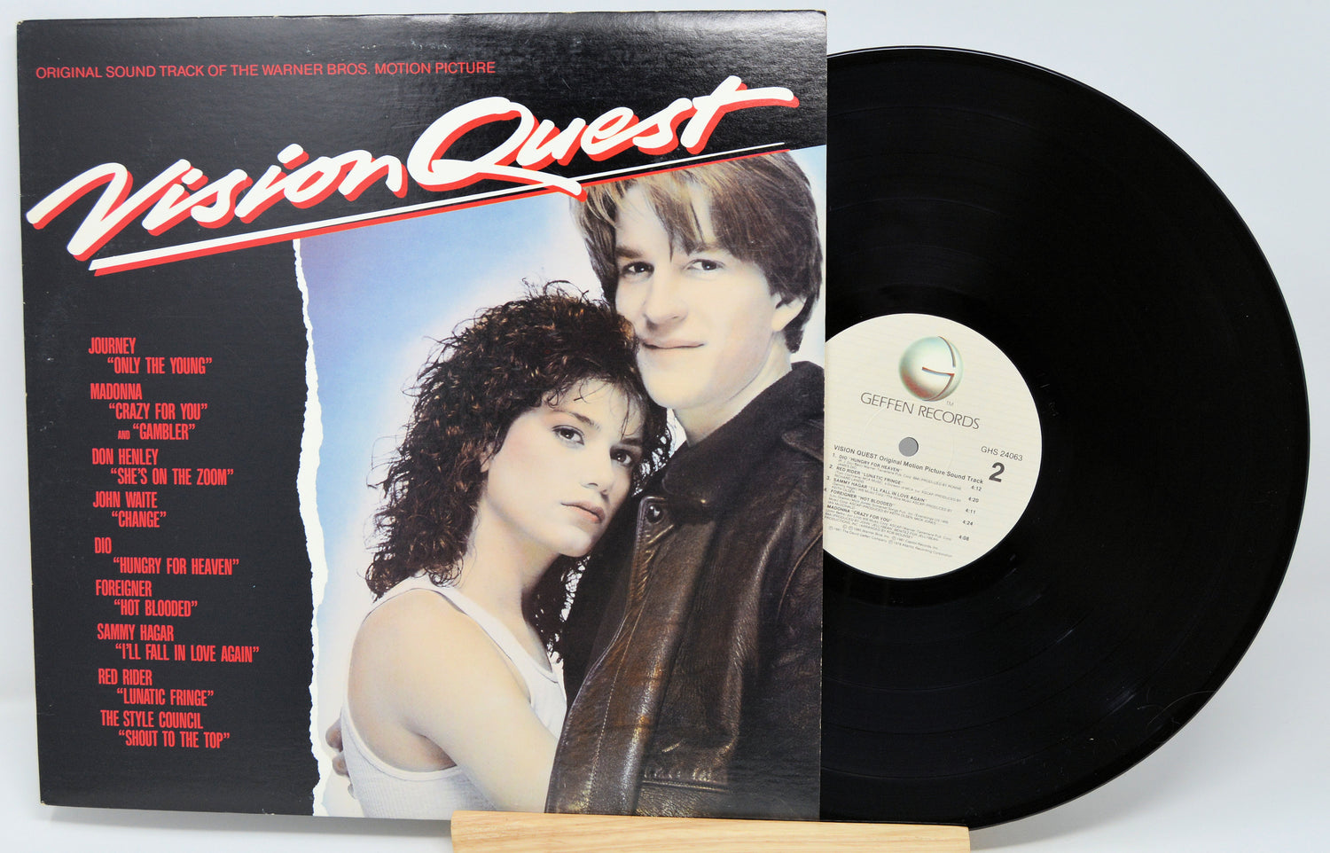 Vinyl record with cover featuring two people and 'Vision Quest' text on a white background