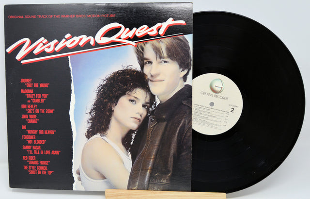 Vinyl record with cover featuring two people and 'Vision Quest' text on a white background