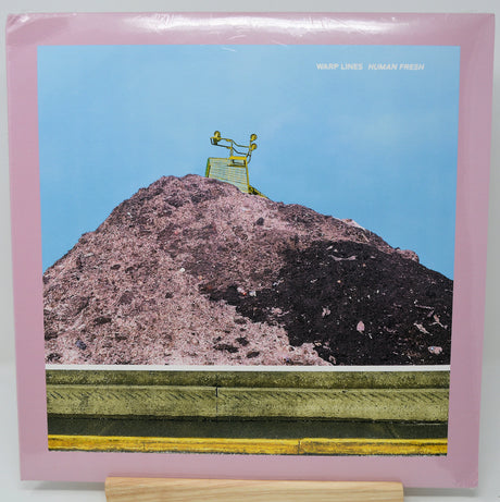 Album cover with a mountain and chair illustration, featuring the text 'Warp Lines Human Fresh'.