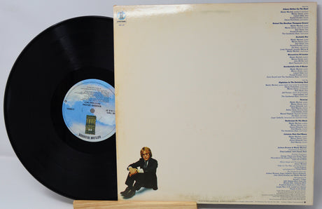 Vinyl record with cover featuring a person sitting and track listings.