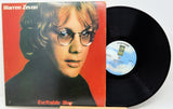 Vinyl record with cover featuring a person's face on a red background