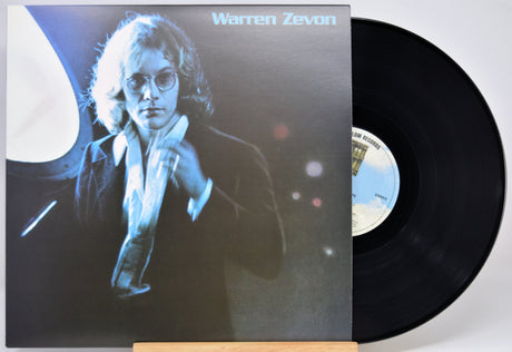 Warren Zevon vinyl record album with the LP partially pulled from the jacket, photographed against a plain light background.