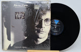 Vinyl record with cover featuring a person and decorative elements on a desert landscape.