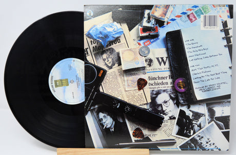 Vinyl record with collage-style cover art featuring various images and text.