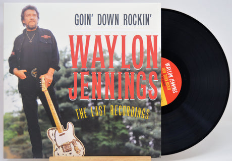 Waylon Jennings 'Goin' Down Rockin'' 'The Cast Recordings' vinyl LP with its printed cover jacket and a black record partially visible behind it.