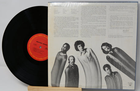 Vinyl record with a black label and a cover featuring black and white images of people.